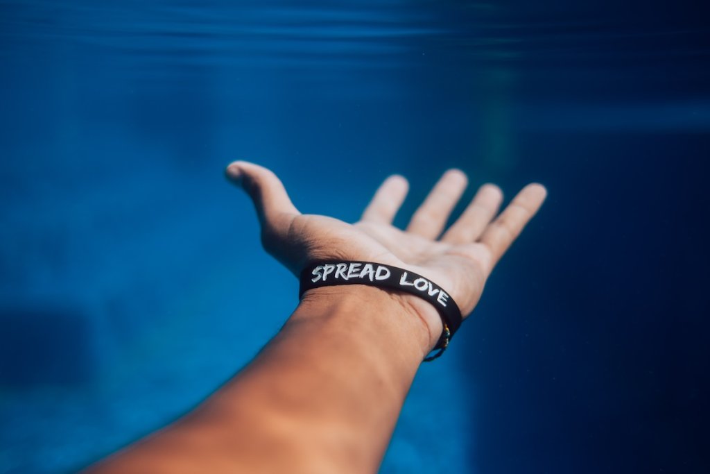 An arm wearing a wristband that says